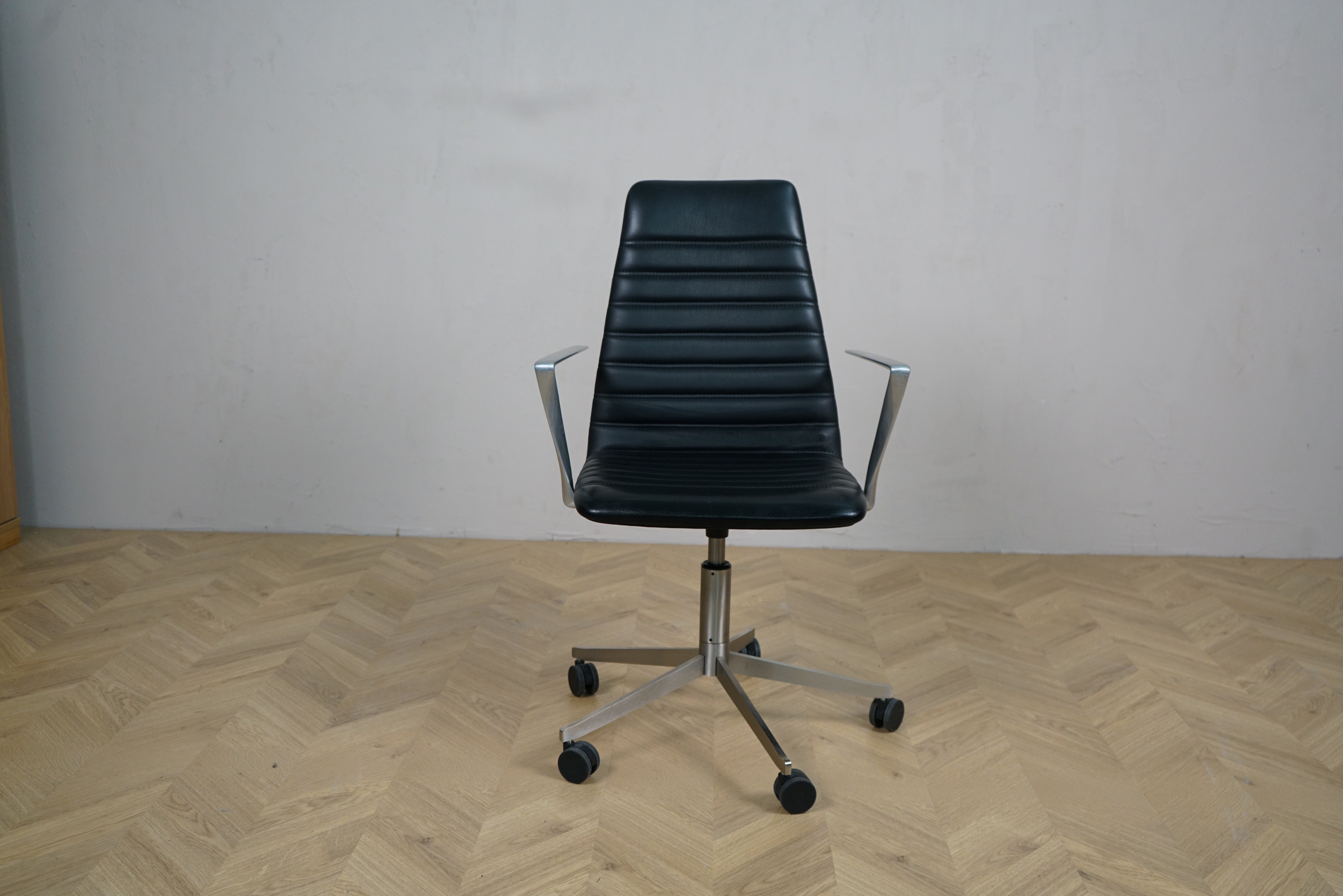 Paustian Spinal kontorstol i sort læder med armlæn og krom stel set forfra.